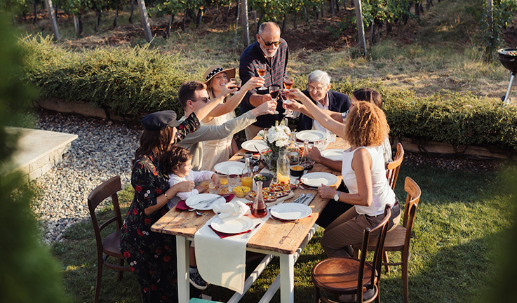 A family toasting around a table in a courtyard. 