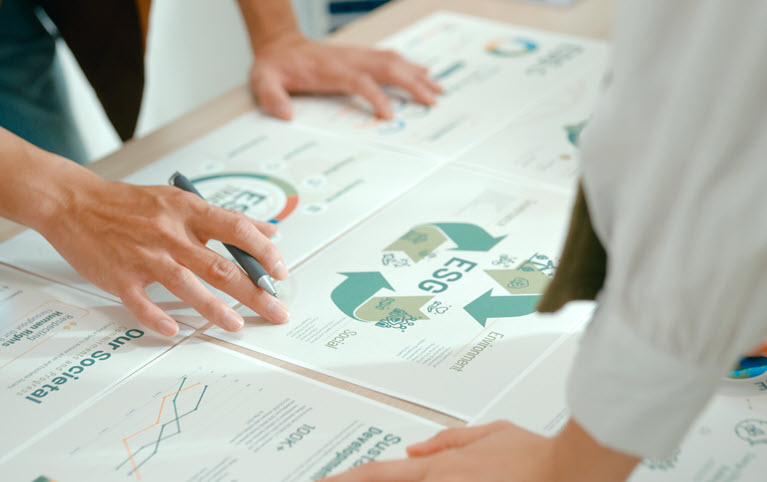 Two hands leaning over a table on which there are reports.