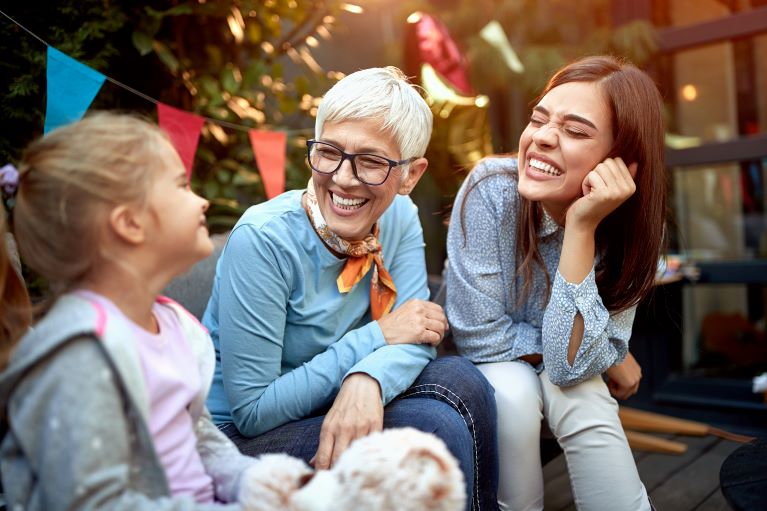 an image representing three generations of women, little girl on the left, grandma in the middle and mother on the right. 