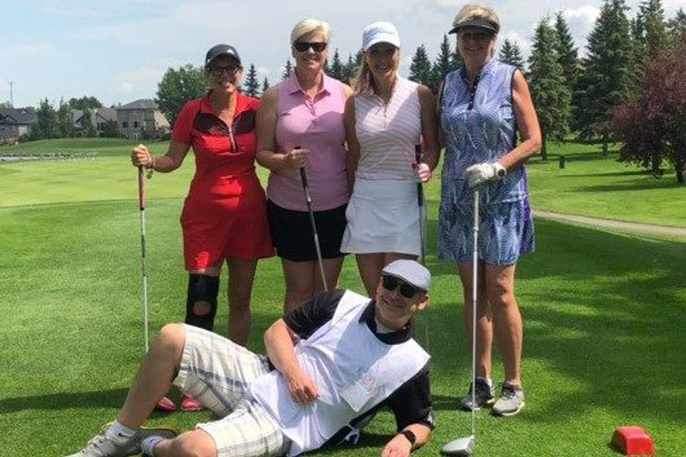 Picture of four women and a man in a golf park