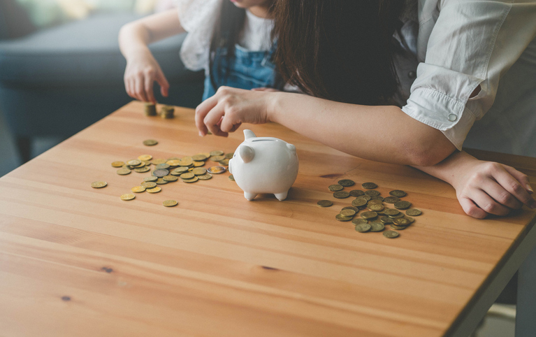 Image of two kids counting the money from their piggy bank.