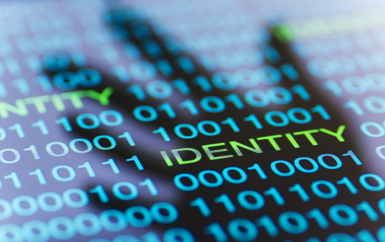 an image of computer code spelling out the word identity with the background of a hand.