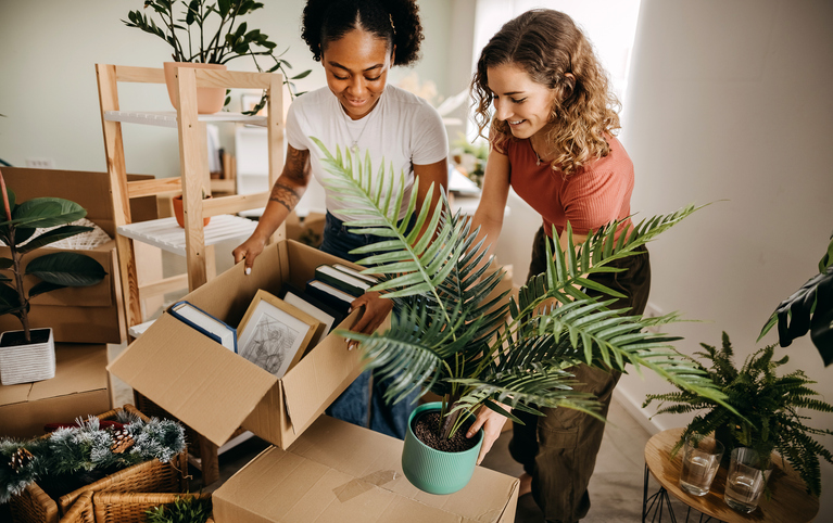 Two female friends helping one move into their newly purchased home