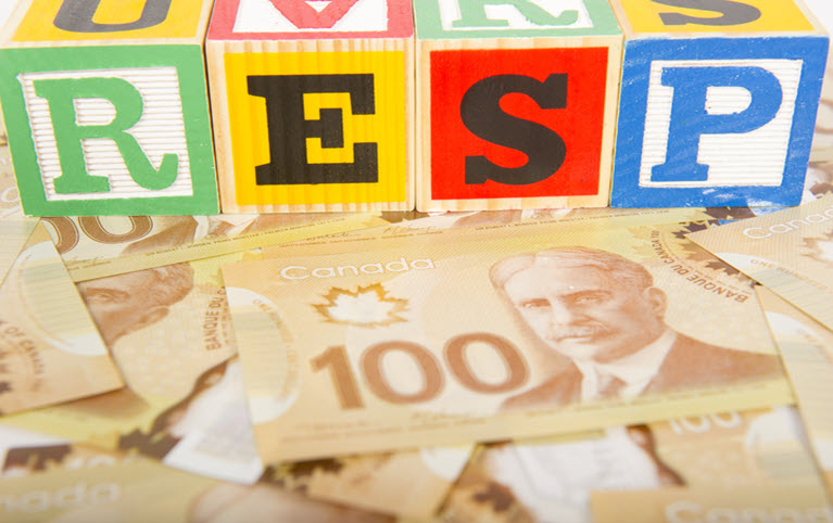 RESP on colourful children's play bricks on top of many Canadian 100 dollar notes.