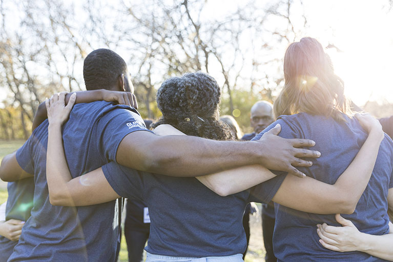 Men and women who form a circle, supporting each other