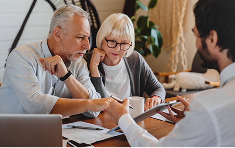 A couple discussing their succession plan with their wealth advisor. 
