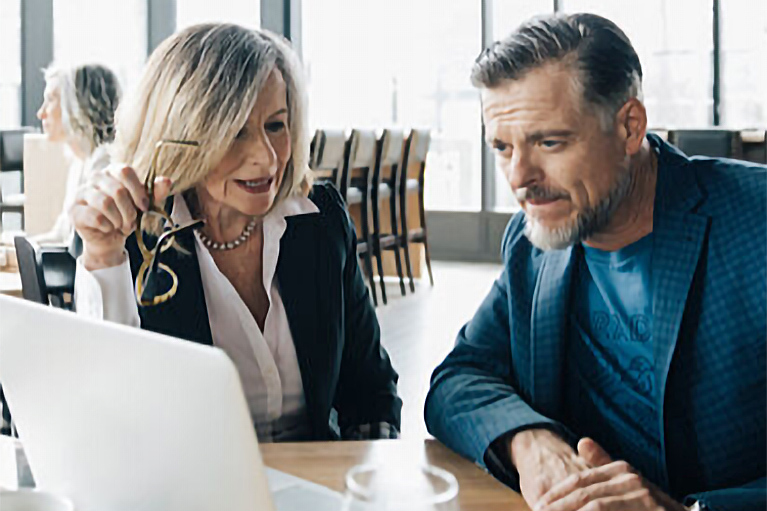 Image of a woman and a man in a restaurant looking at a computer screen.