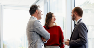 Three persons talking in an office.