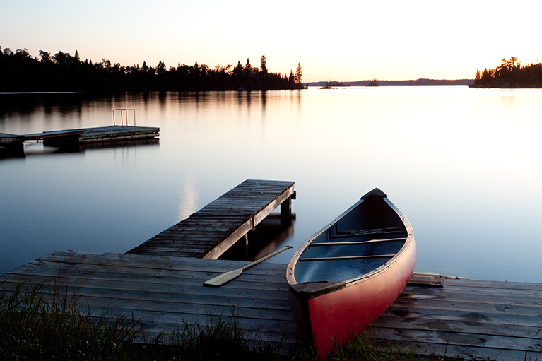 canoe resting on a dock overlooking a lake