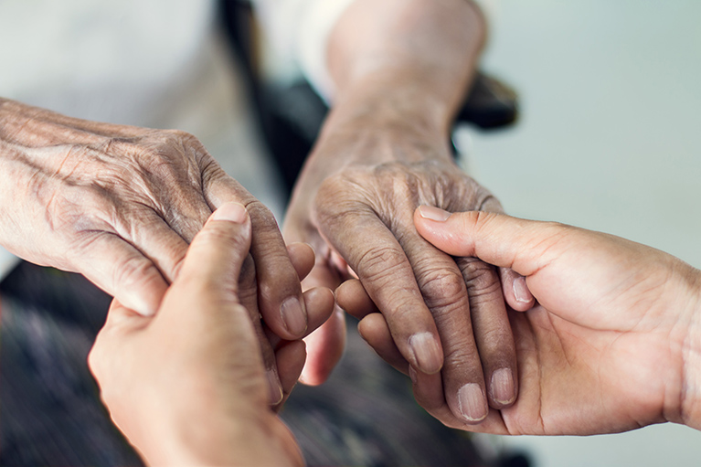 a pair of younger hands holding a pair of older hands