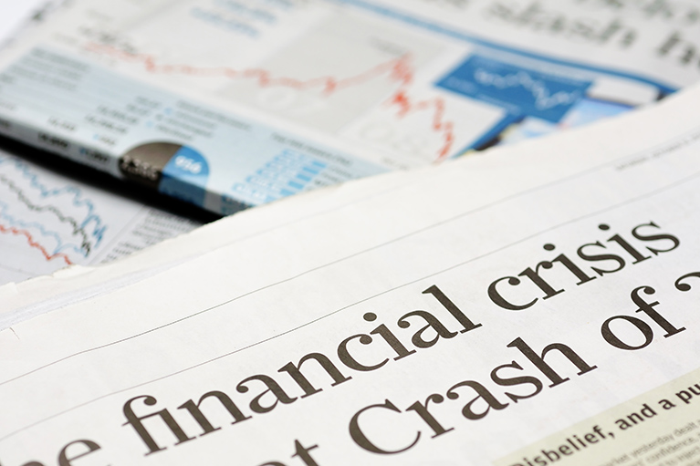 close up on newspaper article with just words "Financial Crisis" showing