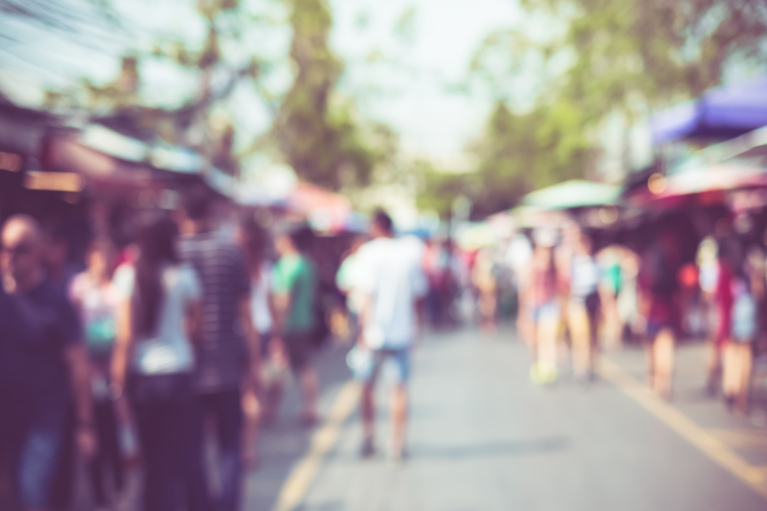 blurred image of people walking in an outdoor market