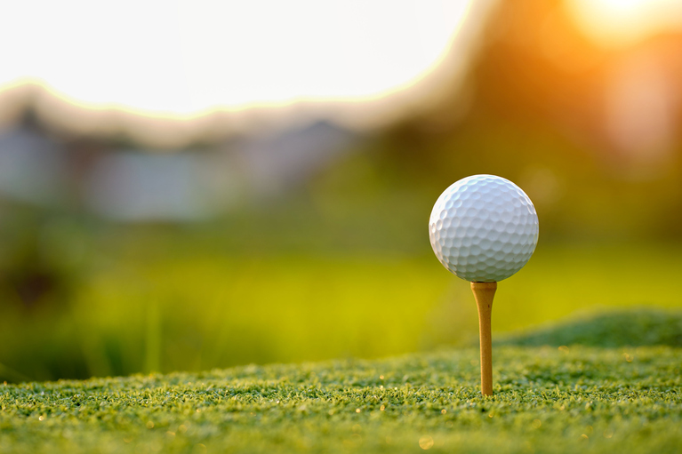 close up of a golf ball on a tee on the green