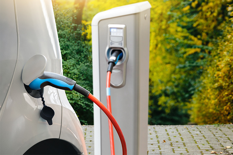Back end of an electric car being charged at an electric charging station