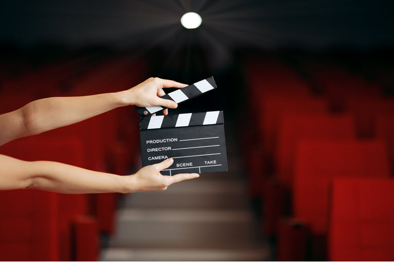 person holding a clapperboard in a theatre