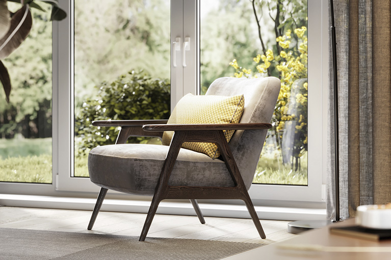 A white armchair, floor lamp, coffee table and bookcase in a room with white walls and wooden floors. 