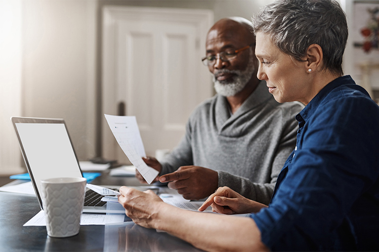 A man and a woman look at investment reports