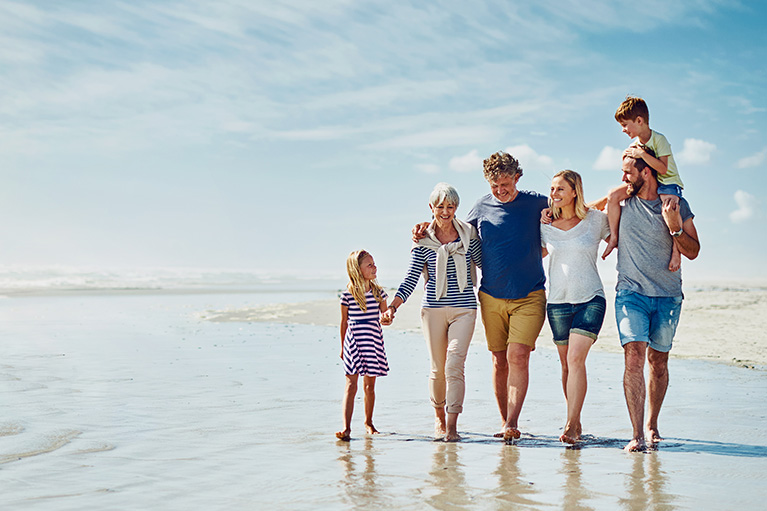 Family walking hand and hand on the beach