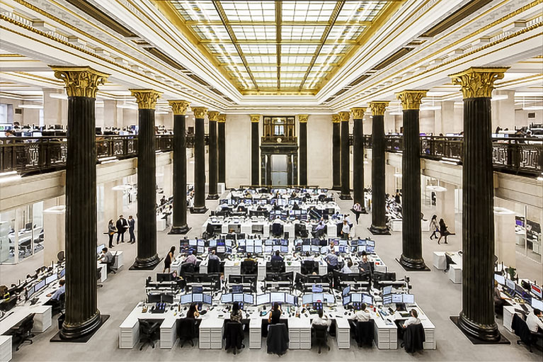 A large space with people working in front of their computer screens.