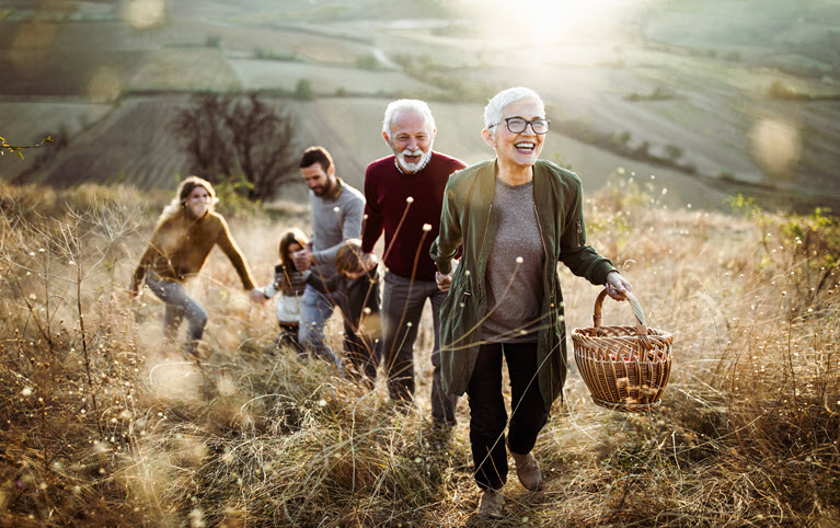 A intergenerational family in a field together on a picnic. 