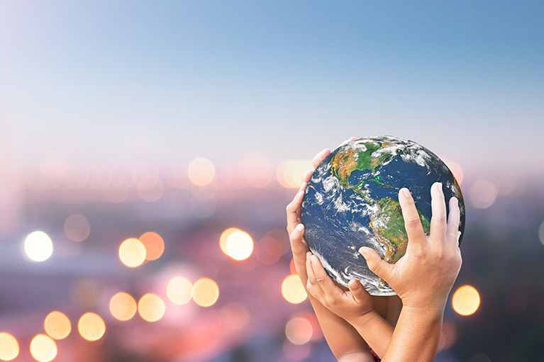 Hands holding a terrestrial globe.