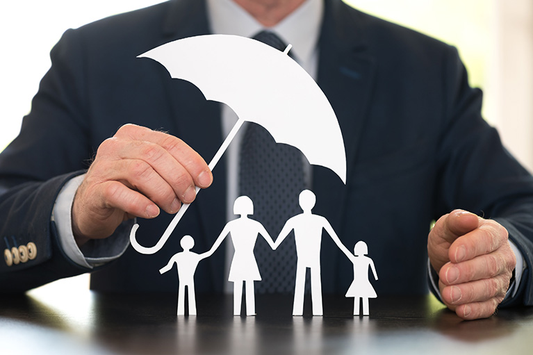 A man holding an umbrella over a paper family