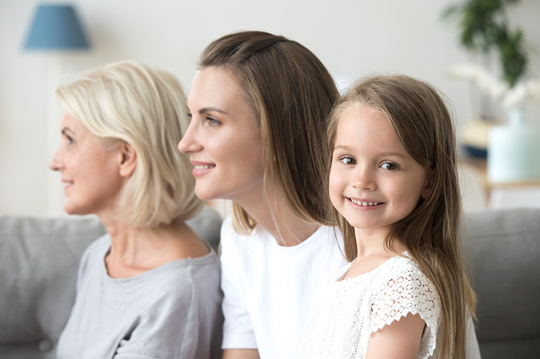 Two women and a girl on a couch.