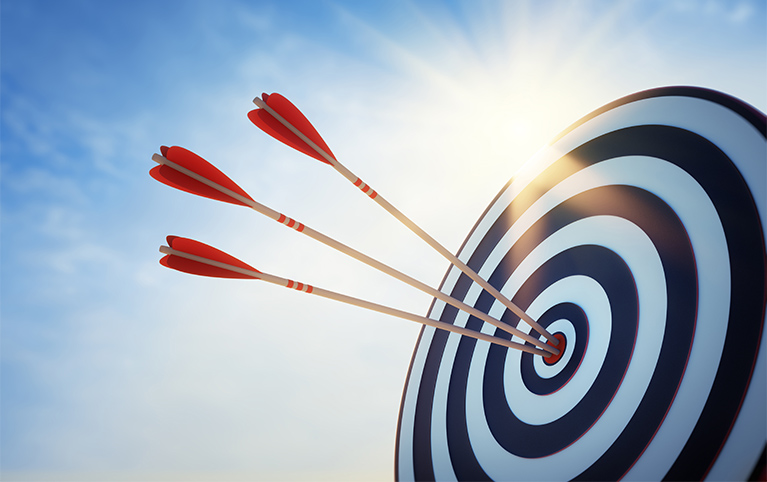 A white and red target with three arrows in the center