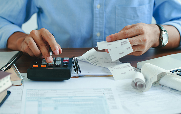 Hand of a man working on a calculator