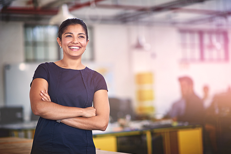 Young woman standing in front of her desk