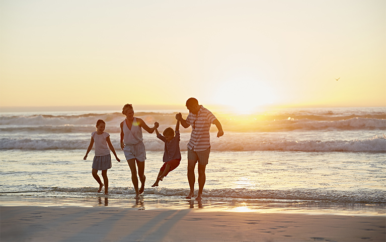 Family on the beach at sunset