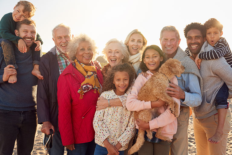 People smiling, a kid hold a dog in his hands.