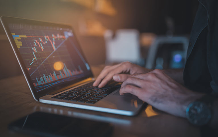 Laptop with graphs representing McMillan Goode Beer Wealth Advisory Group December 2022 newsletter. 