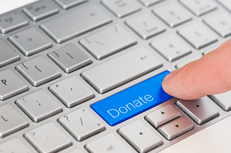 A person clicking Donate key on computer keyboard