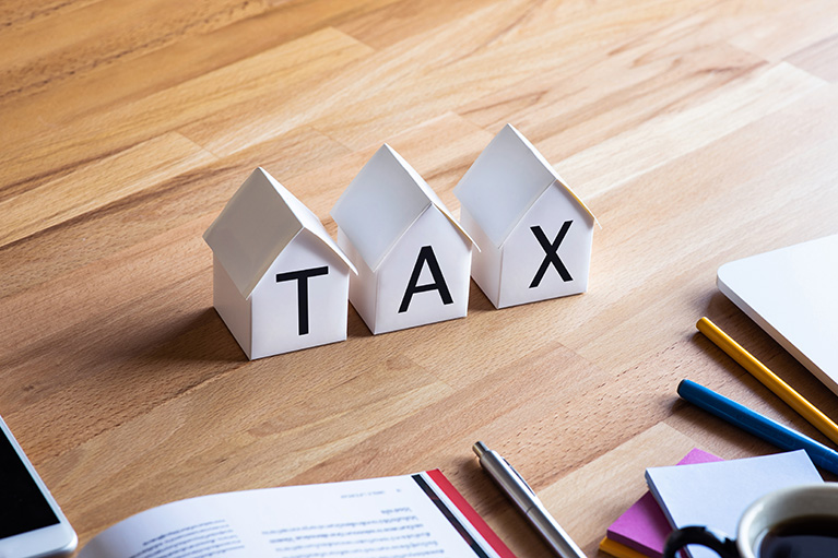 Three small houses grouped together to make the word TAX