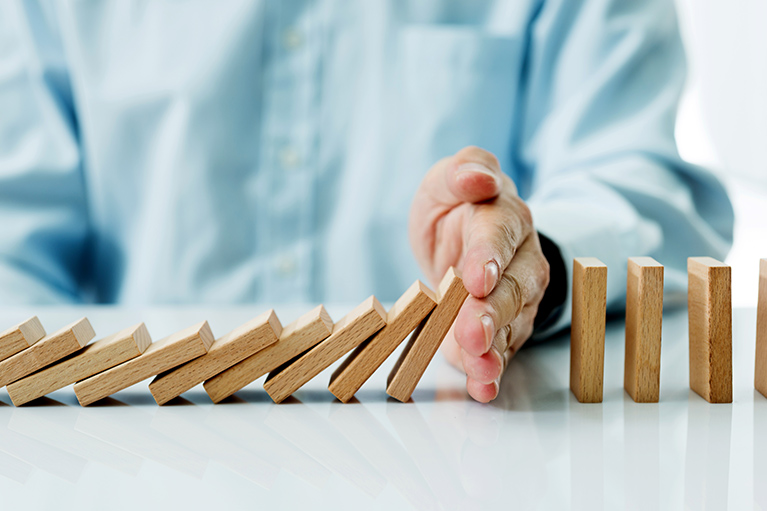 A hand that stops dominoes from falling