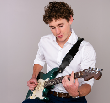 Luke Kingston (Jeff Wiebe Treasury Advisory Team) playing a green electric guitar.