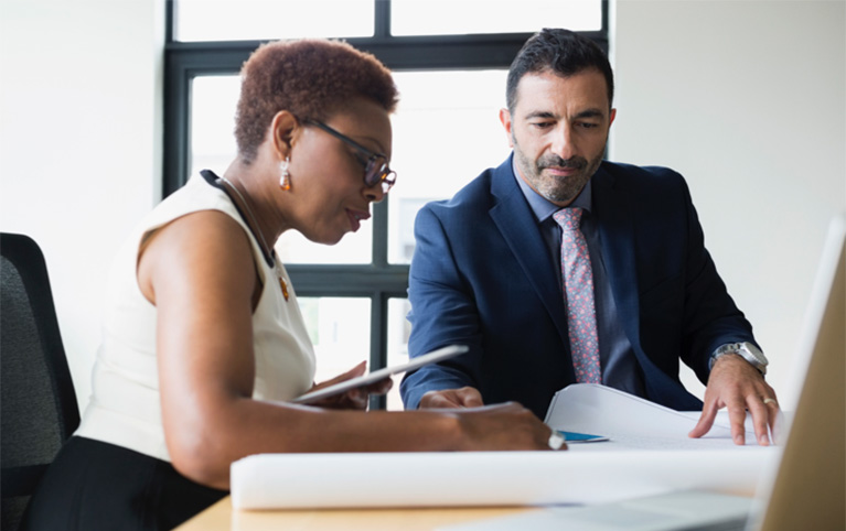 A woman and a man working at a desk together 