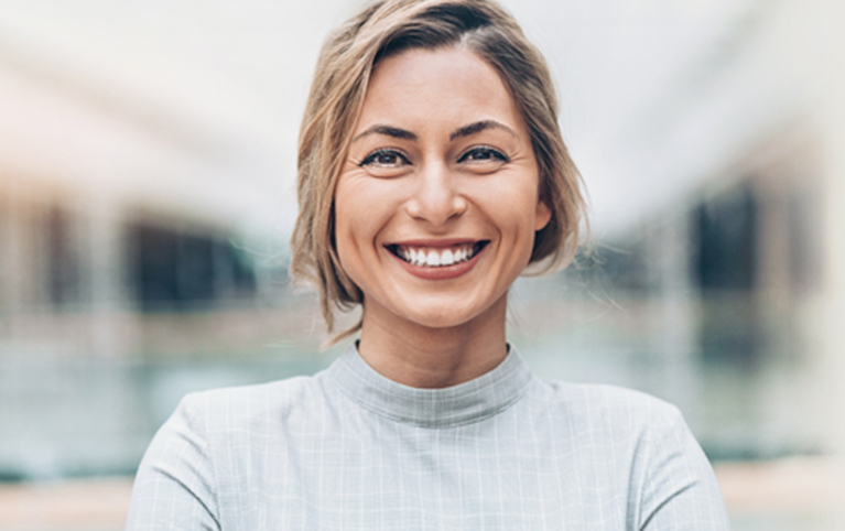 A woman in a grey shirt smiling