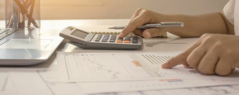 Someone calculating their finances at a desk.