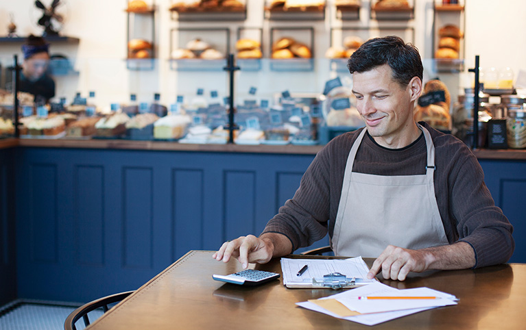 A cafe shop owner doing his taxes for his business.