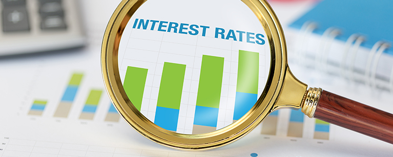 Magnifying glass and calculator on interest rates graph
