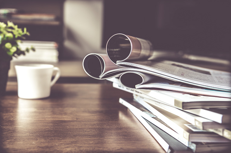  Image of a cup of cofee and newspapers.