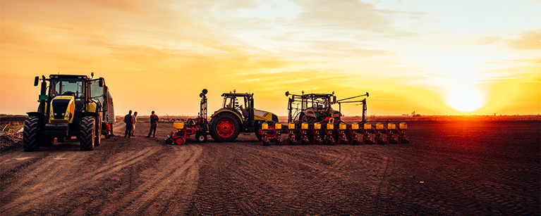 Image of a farm with tractors parked next to one another.