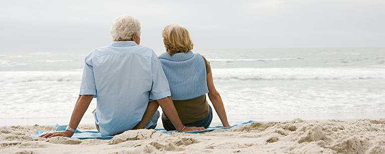 Old couple sitting by the beach.