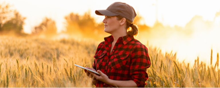 A woman in a corn field representing the 4th Annual Agricultural Excellence Seminar.