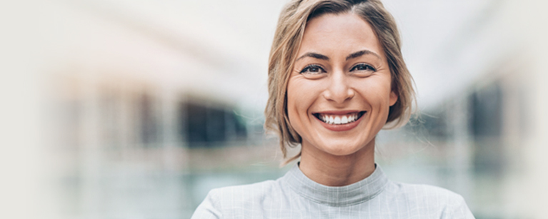 A woman in a grey shirt smiling Link to title: News and Articles page