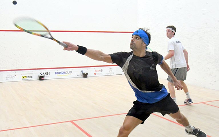 Two men playing squash on an indoor squash court