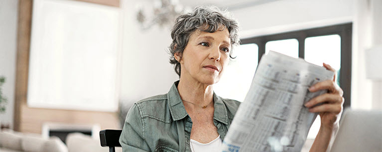 A woman reading special reports detailing important financial updates.