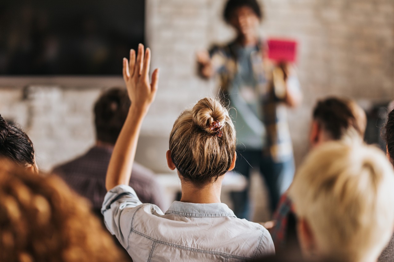 Woman raising hand in class.